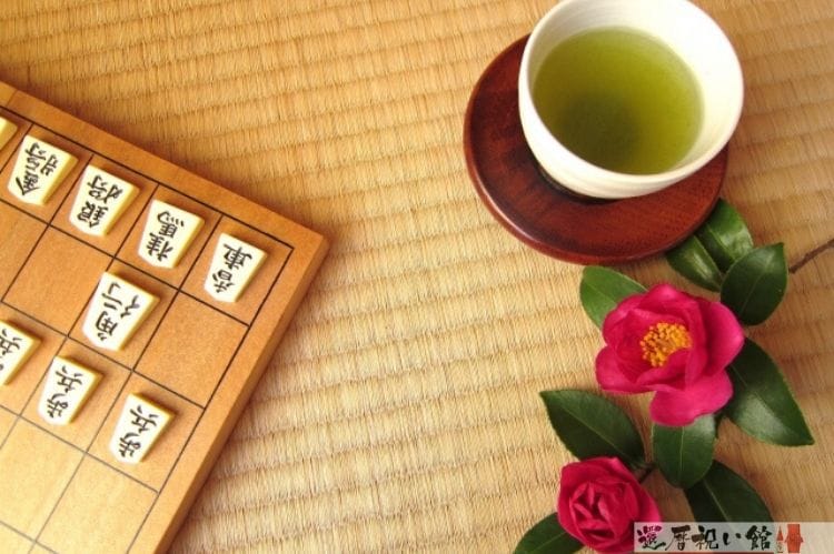 将棋盤と駒とお茶とツバキ