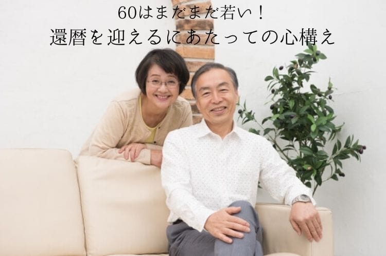 白いソファに座って脚を組んでいるシニア男性とそのソファに寄りかかっているシニア女性