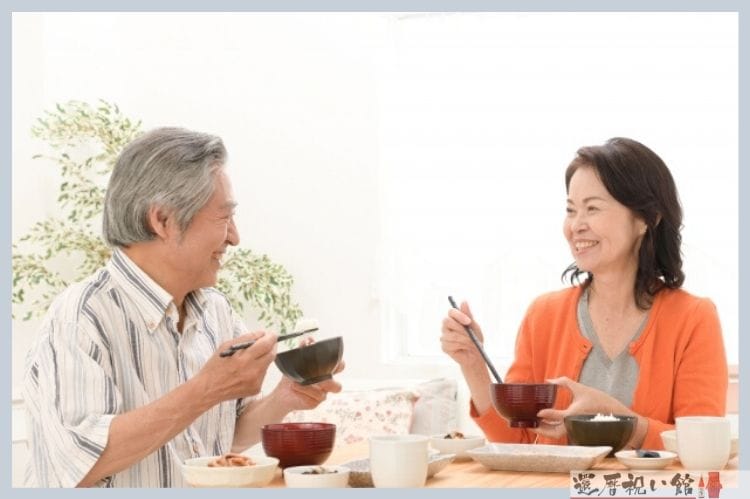 シニア夫婦が食事中に笑顔で話している様子