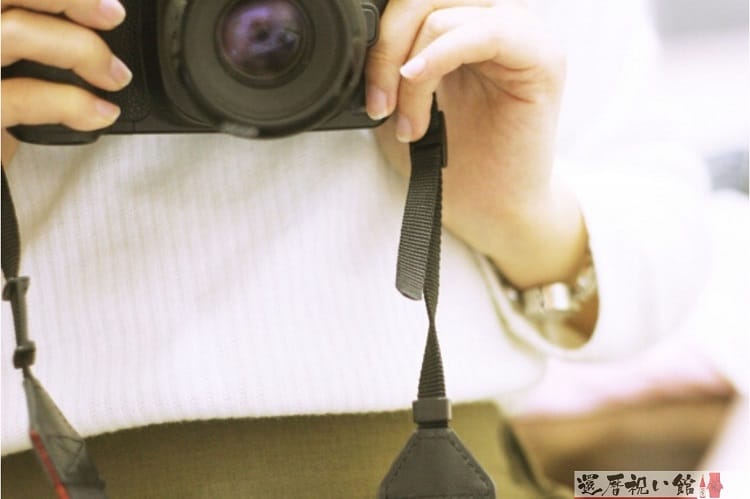 一眼レフカメラを両手で持って今まさに写真を撮ろうとしている様子