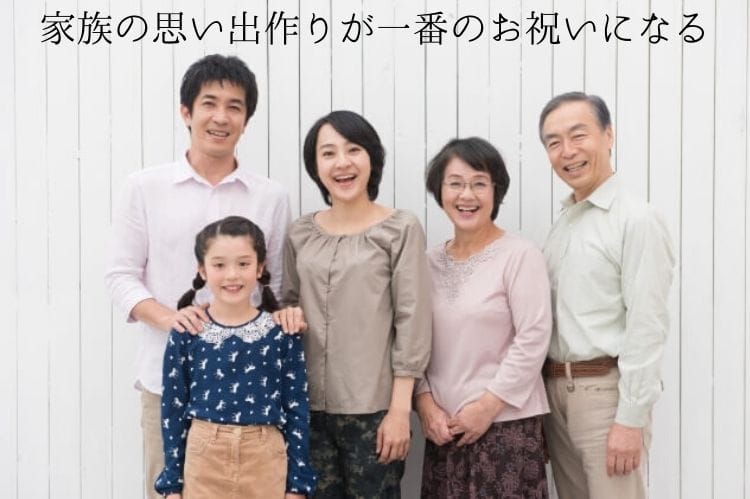 二世帯の家族が笑顔で寄り添って立っている様子