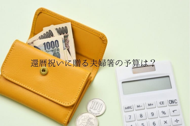 オレンジ色の小さな財布から紙幣が少し出ていて、その隣に100円玉や白い電卓が置いてある様子