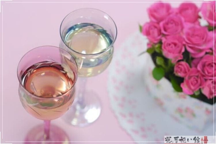 ピンクの薔薇の花束と2つの小さなグラスに入ったお酒