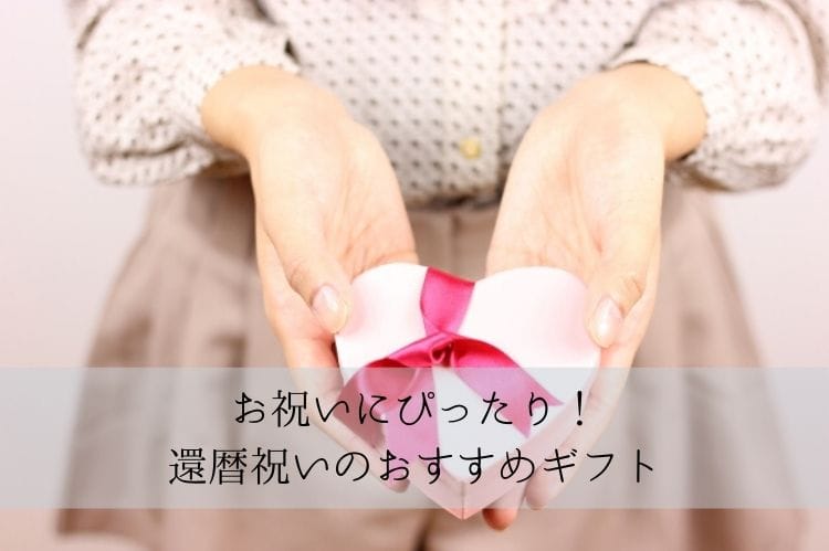 ハート型の小さなギフトボックスを両手の手の平に置いて渡そうとしている女性