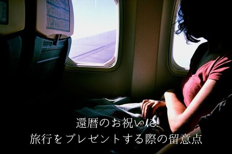 飛行機の窓から外を眺めている女性