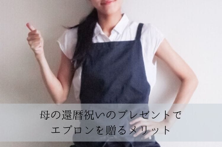 青いエプロンをつけた若い女性が親指をたててグッドサインをしている