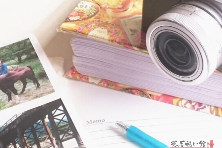 アルバムやカメラ、ボールペン、写真などが無造作に置かれている