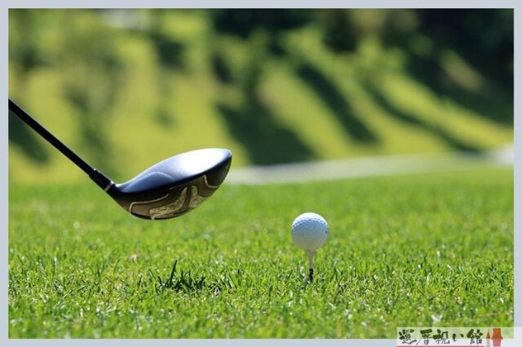 芝にゴルフボールが置かれ今クラブでそのボールを打とうとしている様子