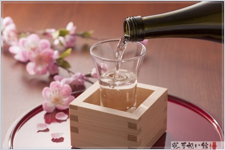 枡の中にグラスが入っていて、そのグラスに日本酒が注がれている