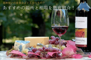 ワインの瓶とそのワインが入ったグラスとチーズ＆ブドウ
