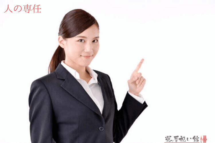 スーツを着た女性が斜め上を指さしている様子