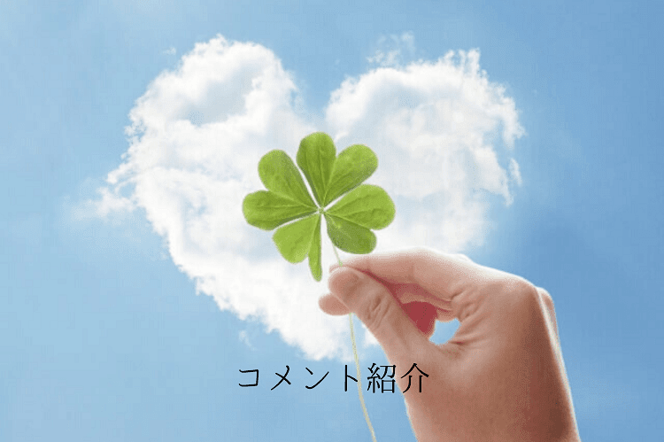 ハートの雲をバックに四葉のクローバーを持つ女性の手