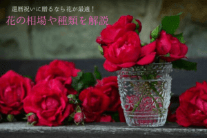 花の柄が彫られたガラス製のコップに赤い薔薇が2,3本入っている様子
