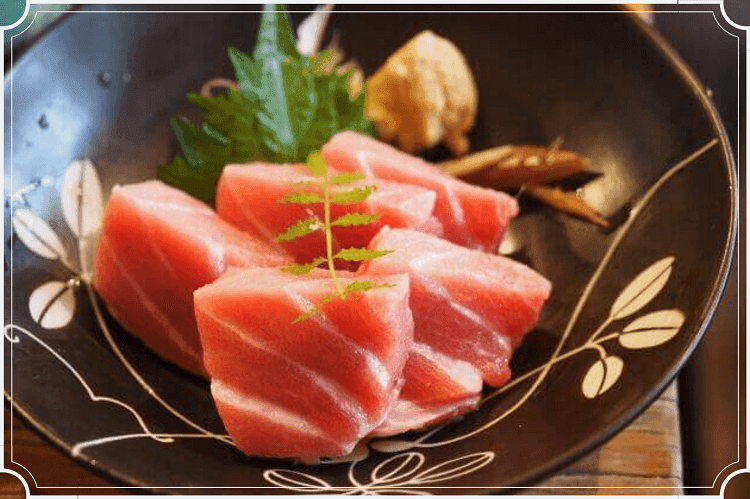 黒い皿の上に四角く切られた刺身が置かれている