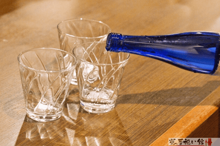 3つのガラス製のグラスに日本酒を注いでいる様子
