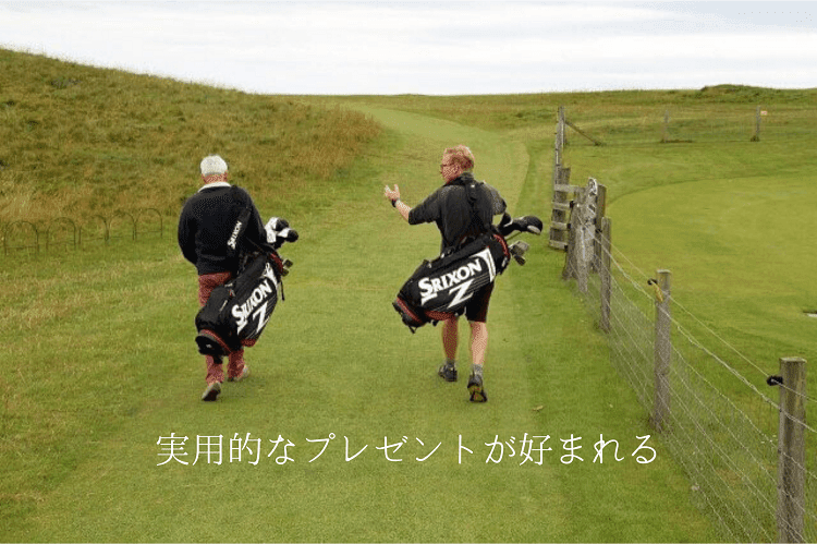 ゴルフバックを背負いゴルフコースを歩く外国のシニア男性2人