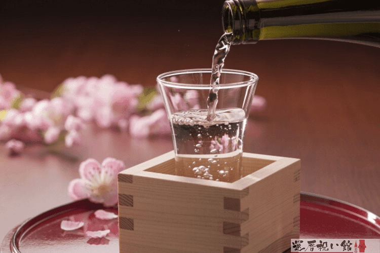 枡に入ったグラスに日本酒をそそぐ