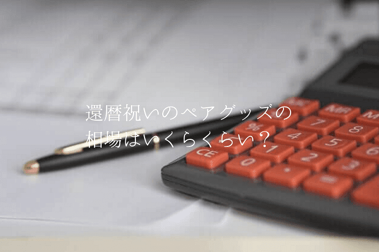 紙の上に置かれたボールペンと電卓