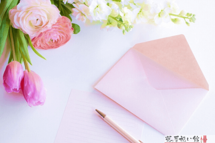 うすいピンク色のレターセットとペンとピンク色の薔薇