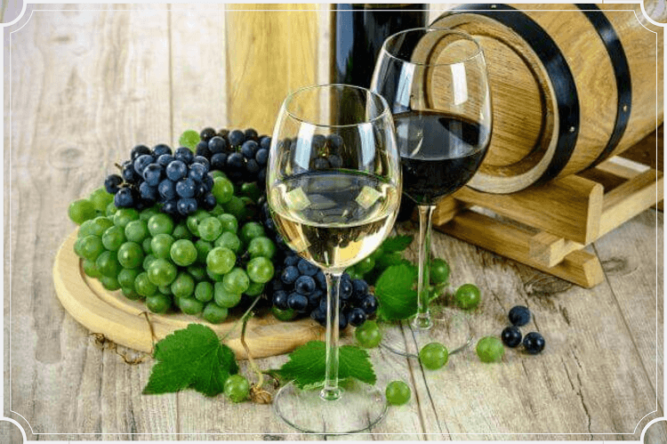 赤＆白ワインの瓶と小さな樽、そのワインが入ったグラス2個とブドウ