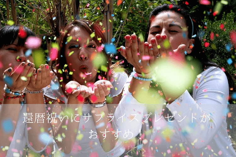 カラフルな紙吹雪を息で飛ばしてお祝いをする3人の外国人女性