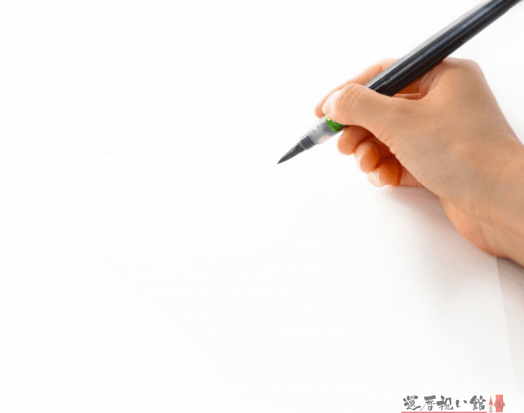 筆ペンで白い紙に何かを書こうとしている様子