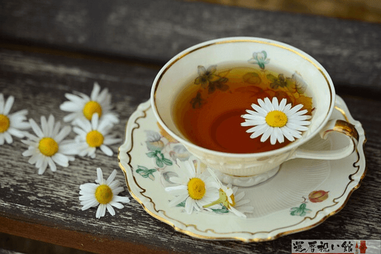 紅茶が入ったティーカップに白くて小さな花びらが1枚浮いている