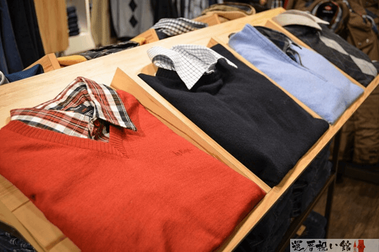 お店に展示されている赤・黒・水色などのセーター