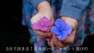 色の違う紫の花を持つ手