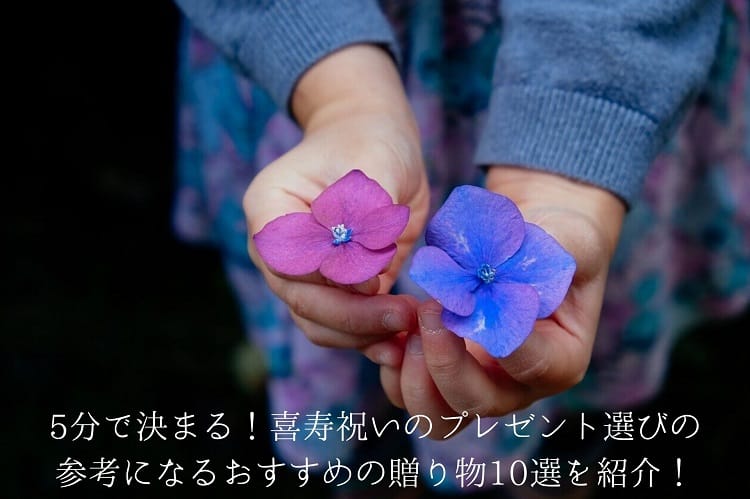 Main avec des fleurs violettes de différentes couleurs