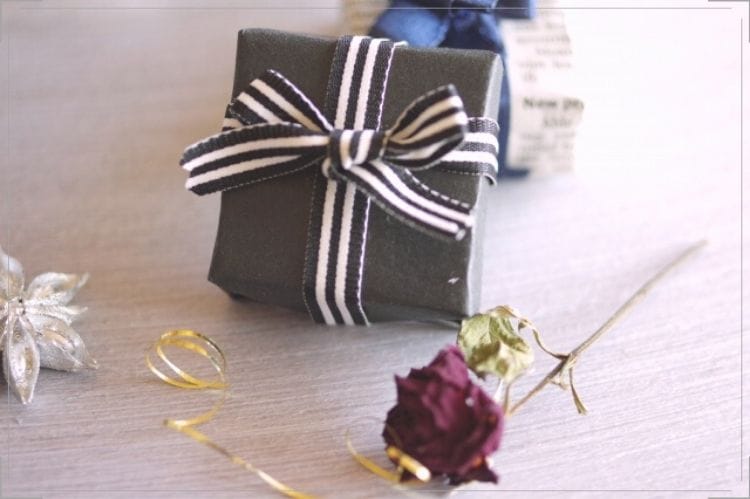 ミニチュアの黒い小さなプレゼントボックスと小さな紫の薔薇