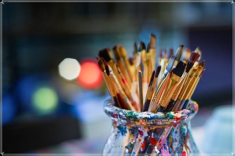 絵の具がちりばめられた瓶に入っているたくさんの絵の具筆