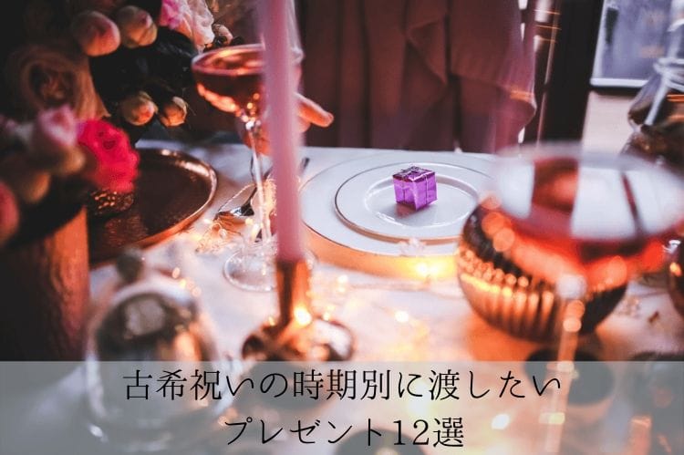 様々な飾りが置かれたテーブルとそこに置かれている白い皿の上の紫色のプレゼントボックス