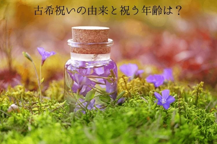 草の上に置かれた透明の瓶とその周りに生えている紫の花