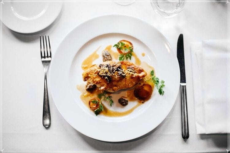 鶏肉を使った洋食料理が白い皿の上に置かれている