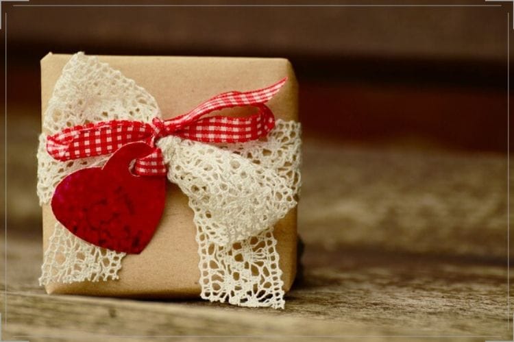 茶色の包みに赤のチェック柄リボンとレースが付いたプレゼントボックス