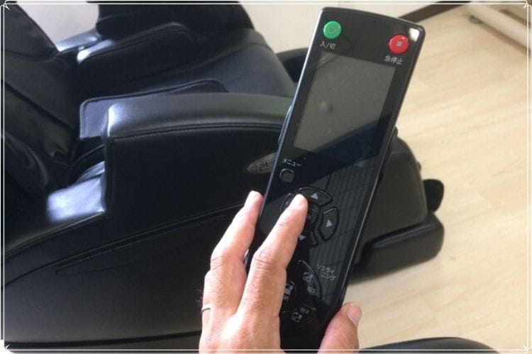 マッサージチェアのリモコンを持っている手
