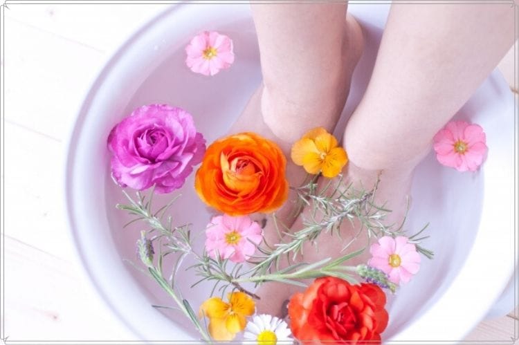 足湯のお湯に色とりどりの花を浮かべて楽しんでいる様子