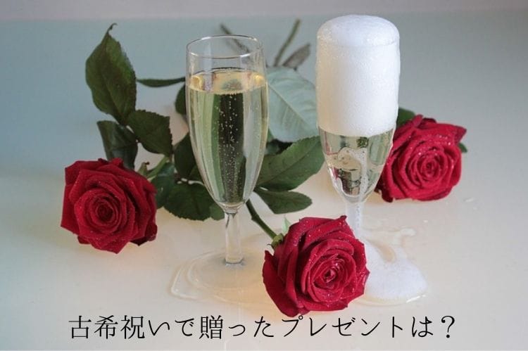 シャンパンが入ったグラス2個と赤い薔薇3つ