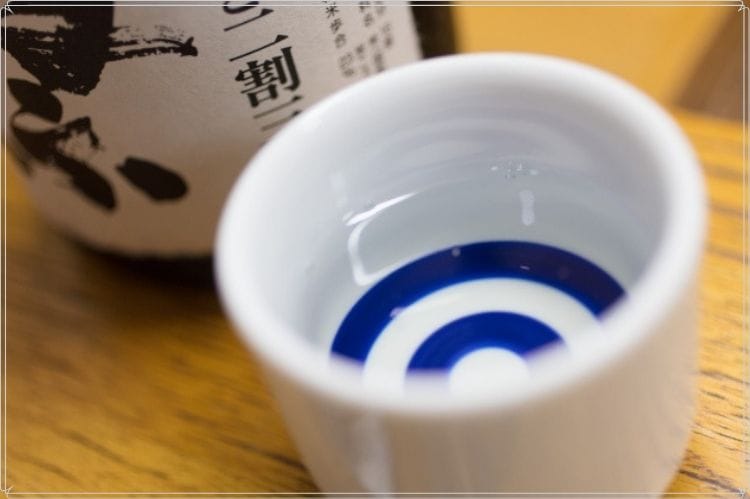 日本酒の瓶と日本酒が入ったおちょこ