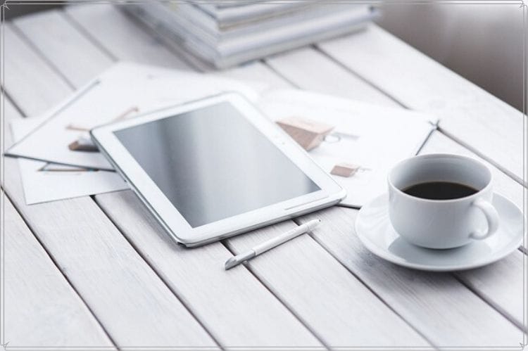 コーヒーとタブレットと何かのカタログ