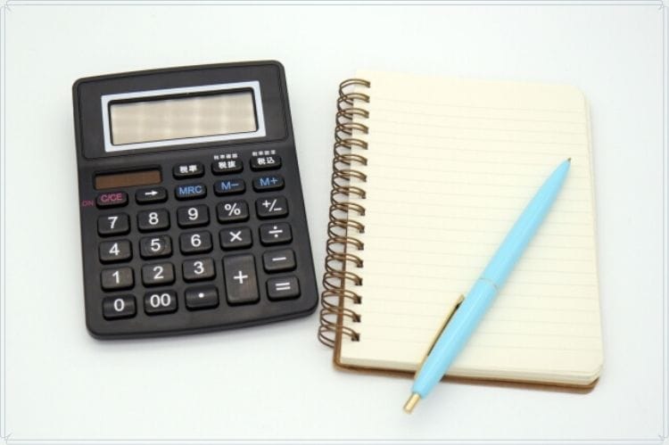 小さなメモノートと水色のボールペンと黒い電卓