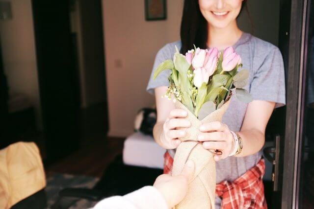 A photo giving a bouquet to a woman