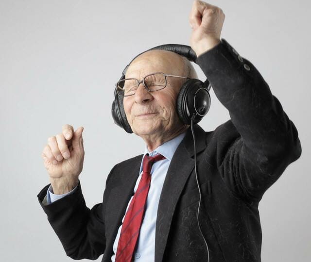ヘッドホンをつけて楽しんでいる80歳の男性