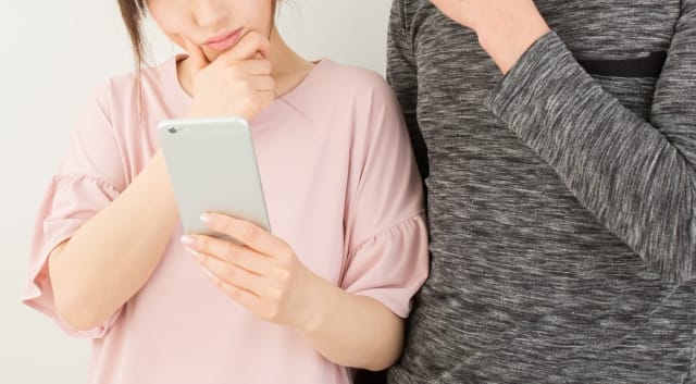 携帯を見るカップル