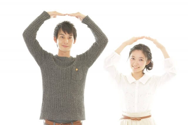 まるのサインをするカップル