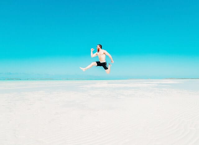 海辺をジャンプする男性