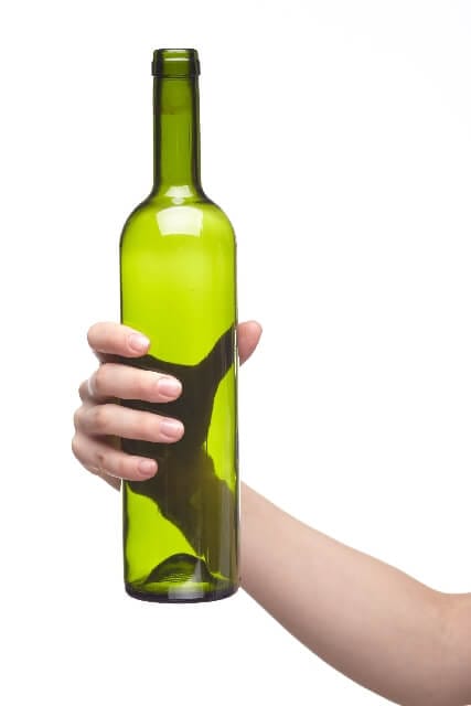 Mão segurando a garrafa de vinho vazia