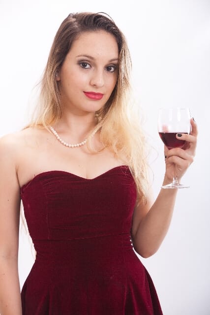 Donna con vino rosso in abito rosso