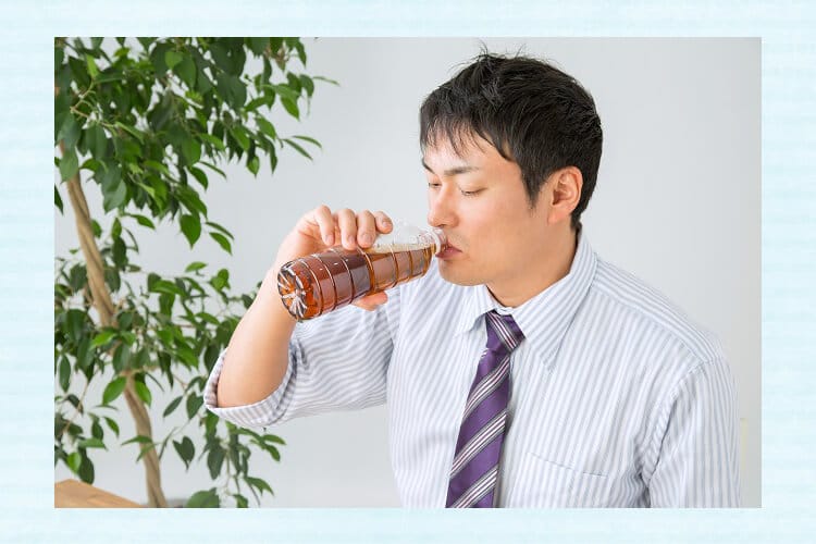 ペットボトルのお茶を飲むサラリーマン